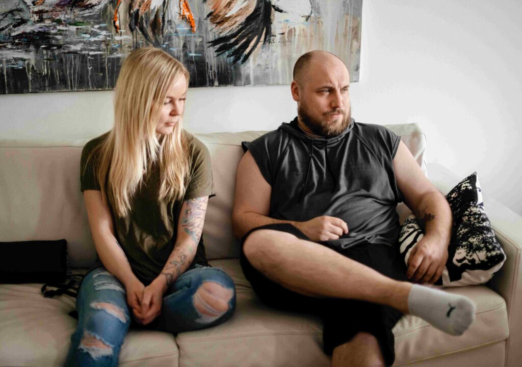 Nainen ja mies istuu sohvalla