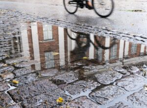 Pyörän kuva heijastuu vesilätäköstä