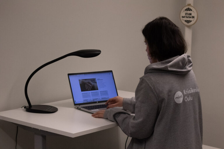 ihminen on tietokoneen äärellä ja tekee työtä sillä