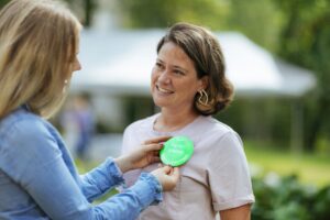 Henkilö ohjentaa toisen rintaan vihreän merkin