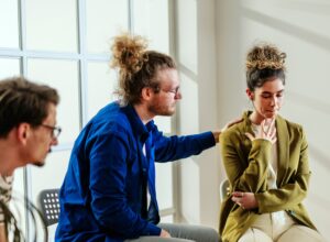 Kolme ihmistä, yksi lohduttaa toista