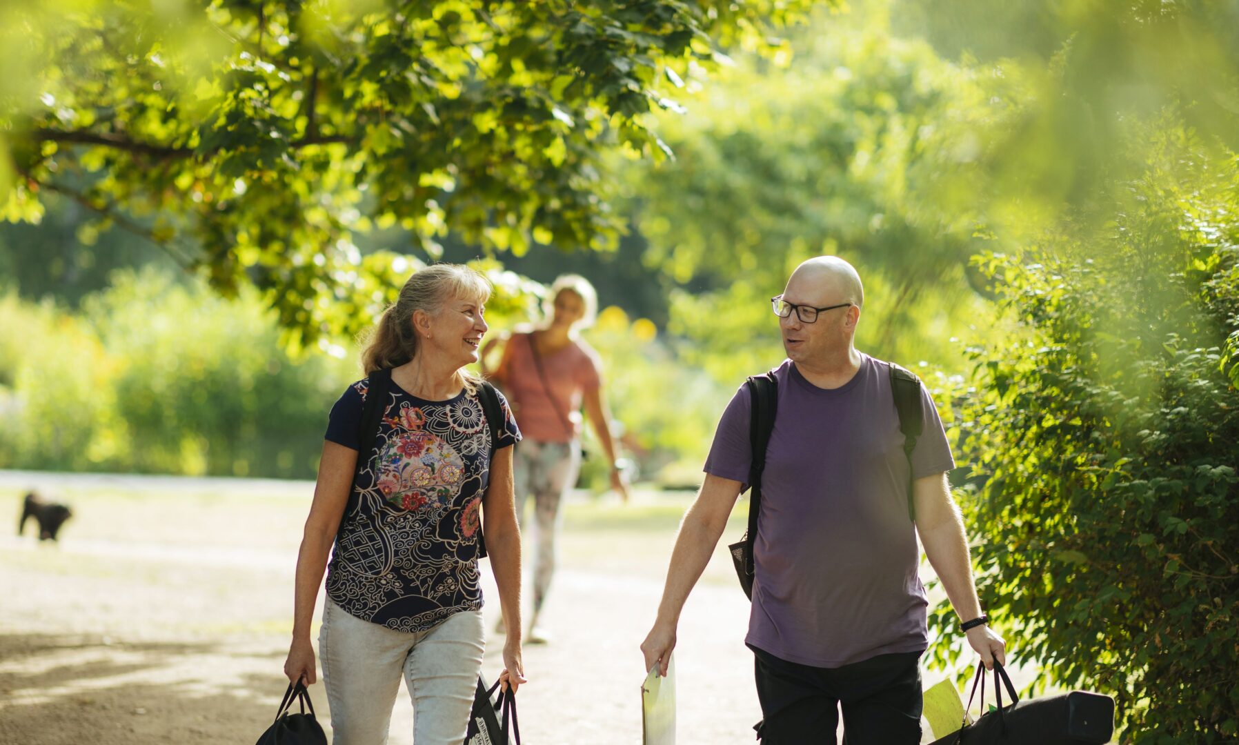Kaksi hymyilevää ihmistä puistossa